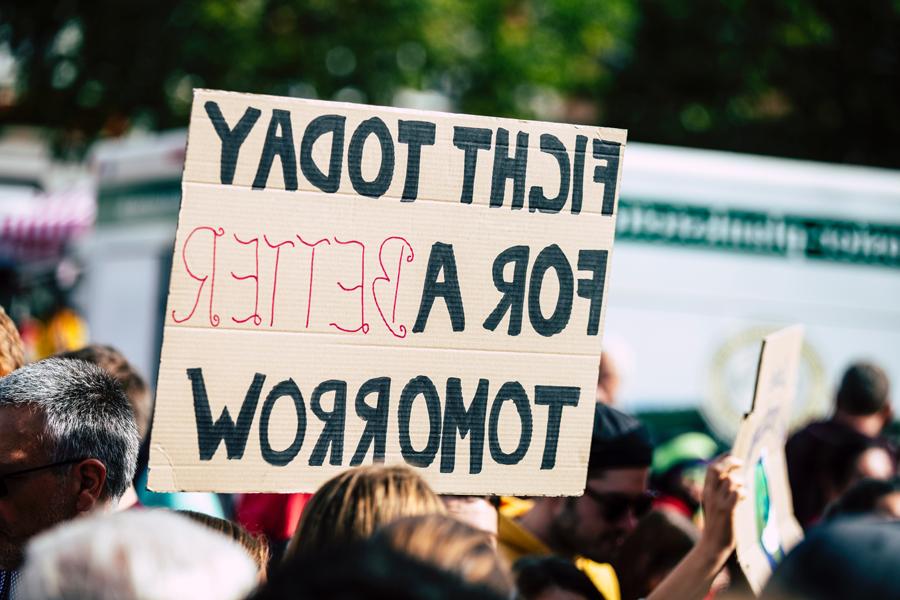 A person holds a sign that says Fight For a Better Tomorrow.